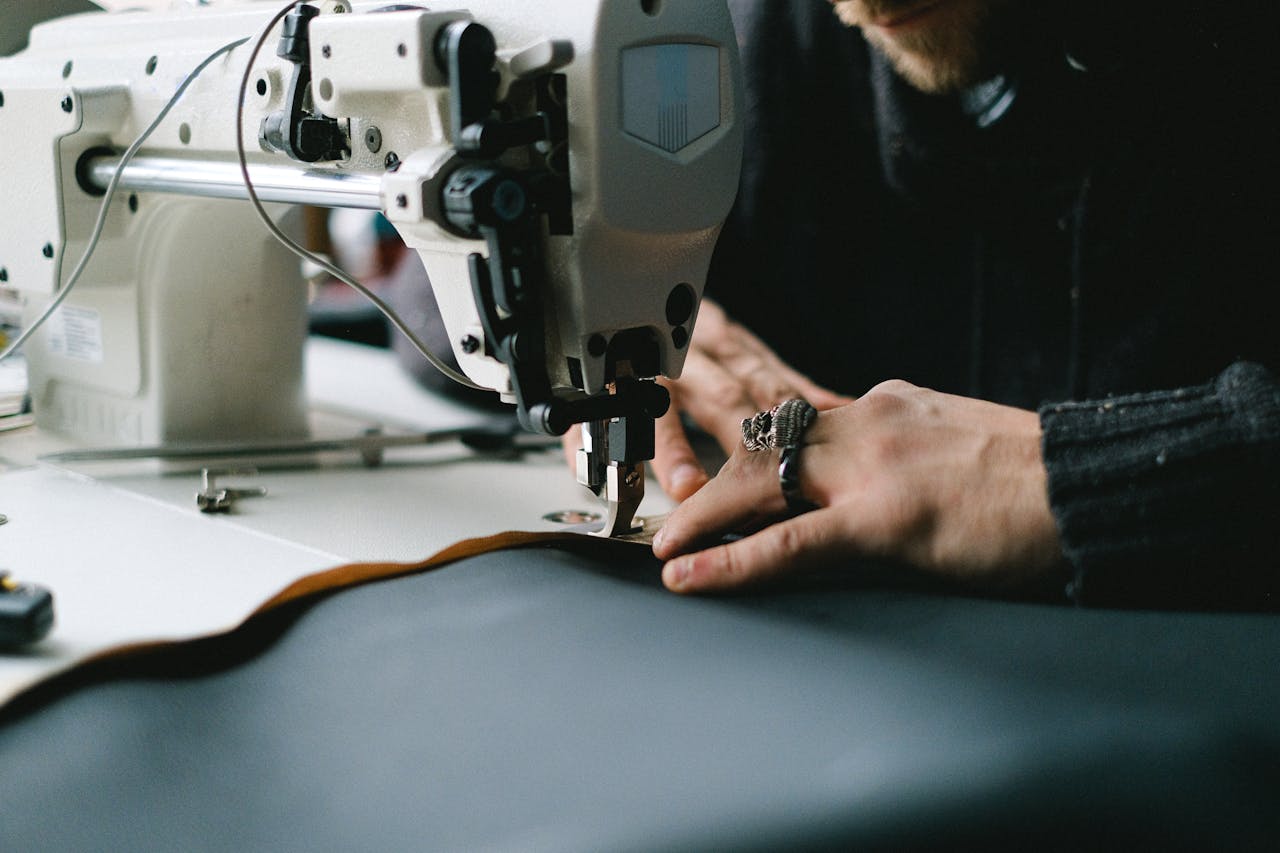 Close-up of hands using an industrial sewing machine to create garments.